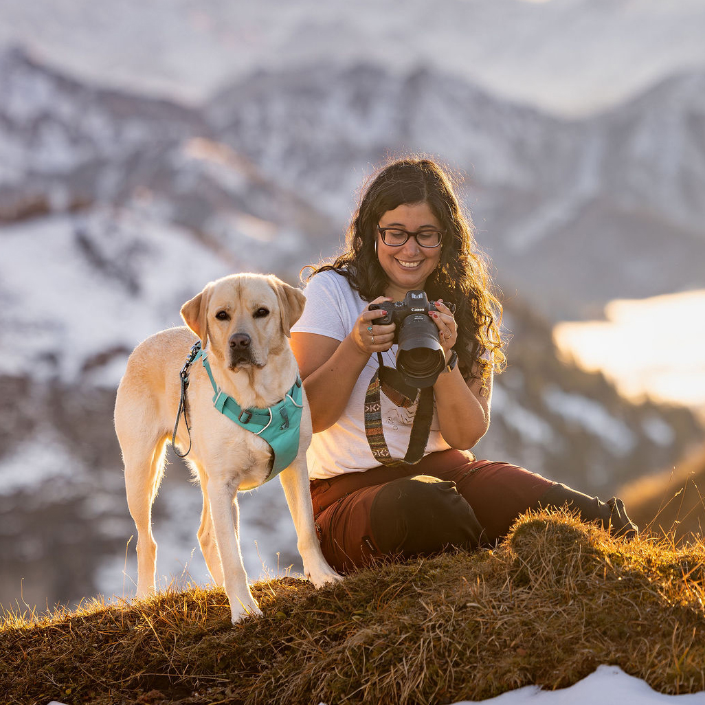 Sofia photographe pour animaux de compagnie et leurs humains en suisse, en compagnie de son chien Toast dans les montagnes.