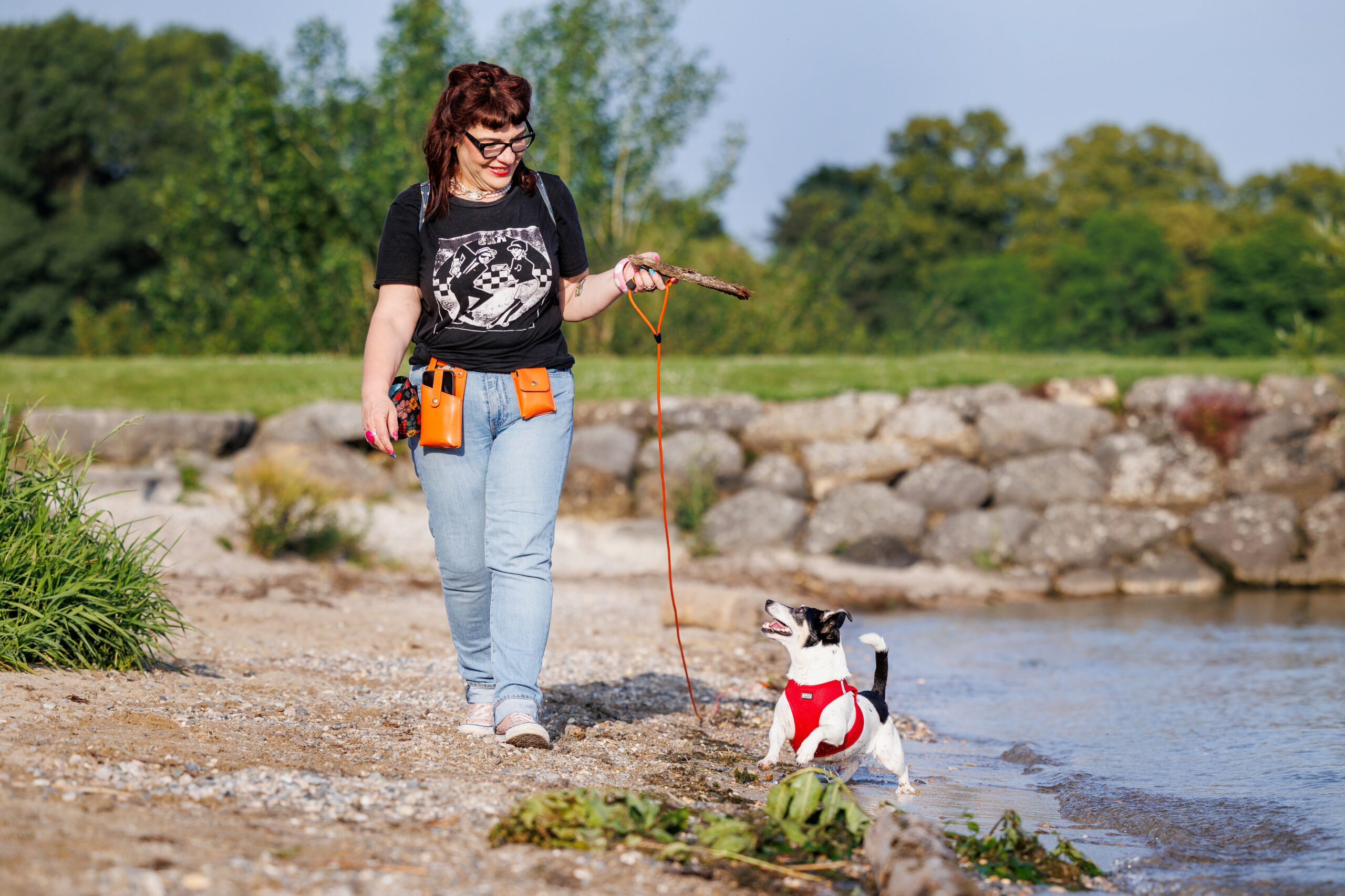 Chien jack russel qui marche avec son humaine au bord de la plage du lac de Neuchâtel à St-Blaise pendant sa séance photo. 